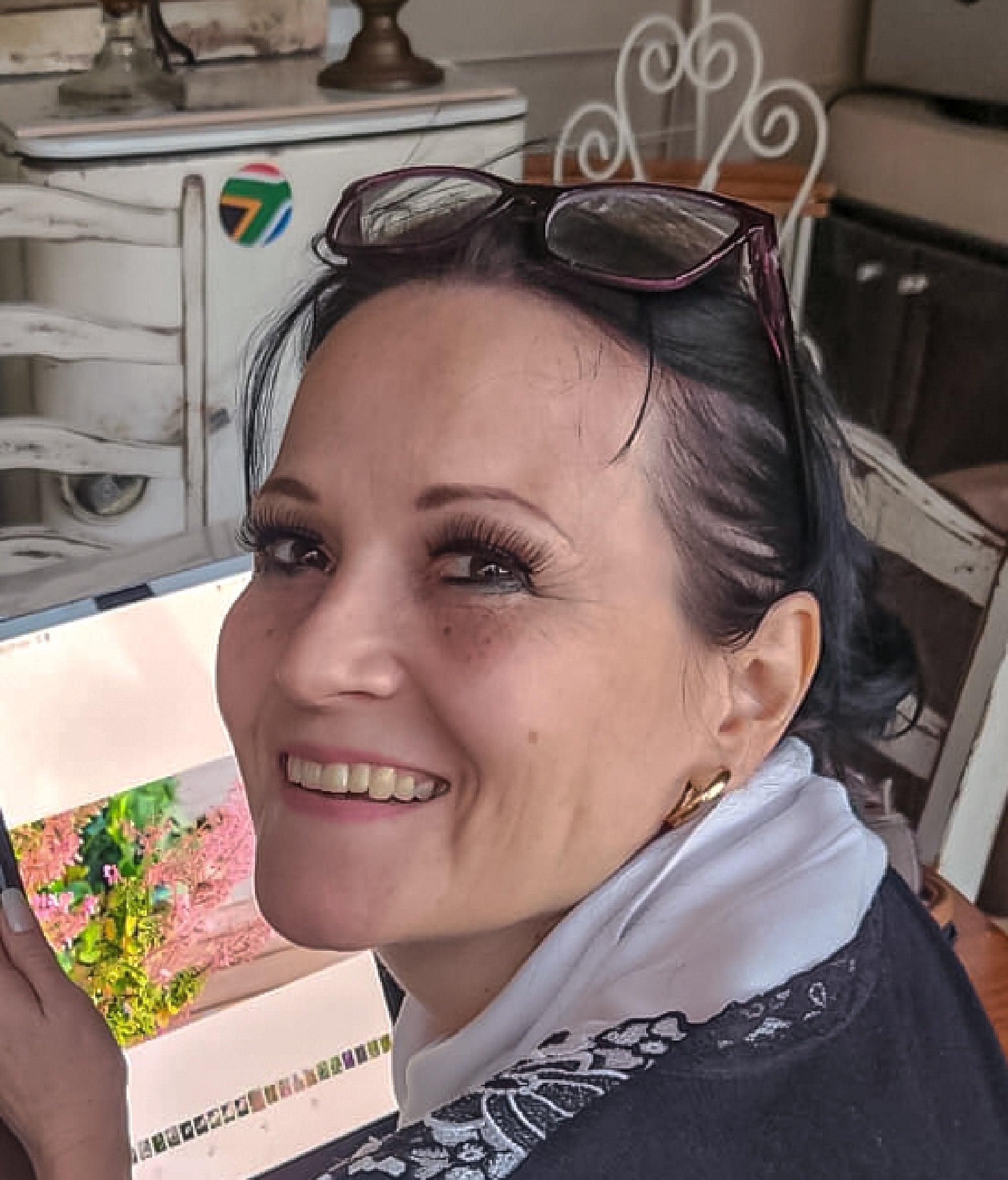 Woman with sunglasses on head smiling in a kitchen setting
