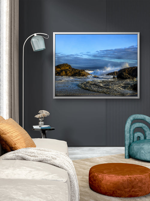 Living room with a framed picture of a coastal scene on the wall.