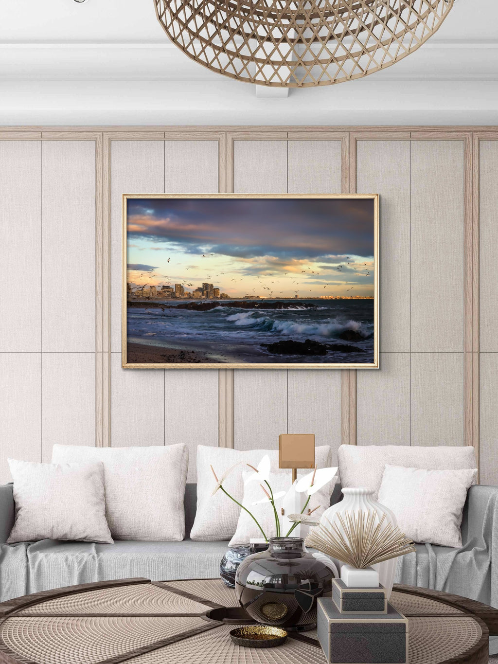 Modern living room with a framed landscape painting on the wall, gray sofa, and decorative items.