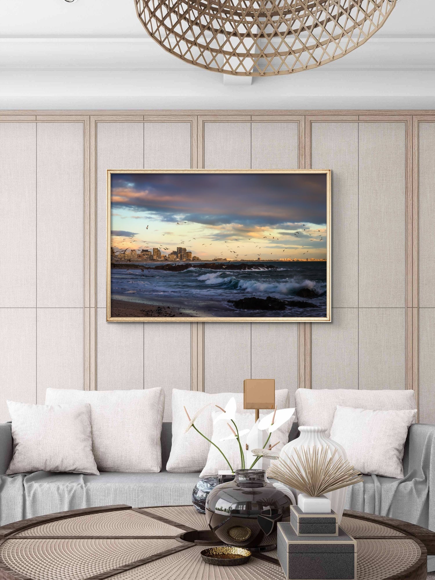 Modern living room with a framed landscape painting on the wall, gray sofa, and decorative items.