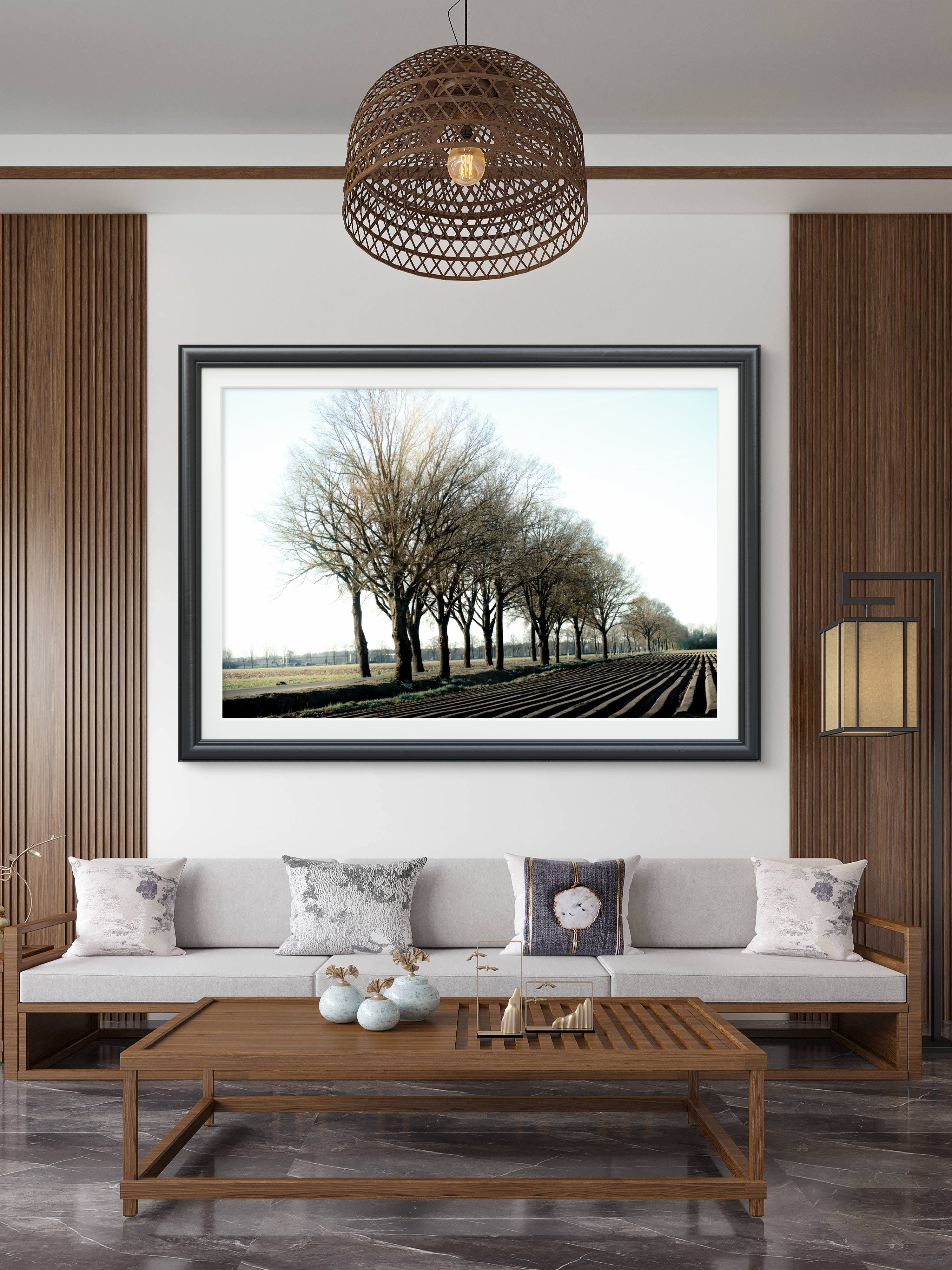 Living room with a framed landscape picture on the wall, wooden coffee table, and gray sofa.