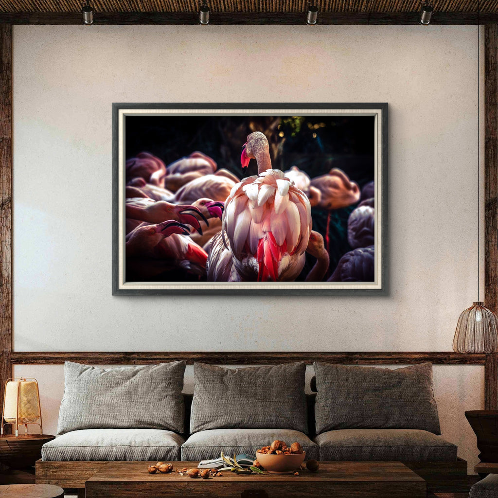 Framed artwork of a flamingo on a wall above a sofa in a living room.