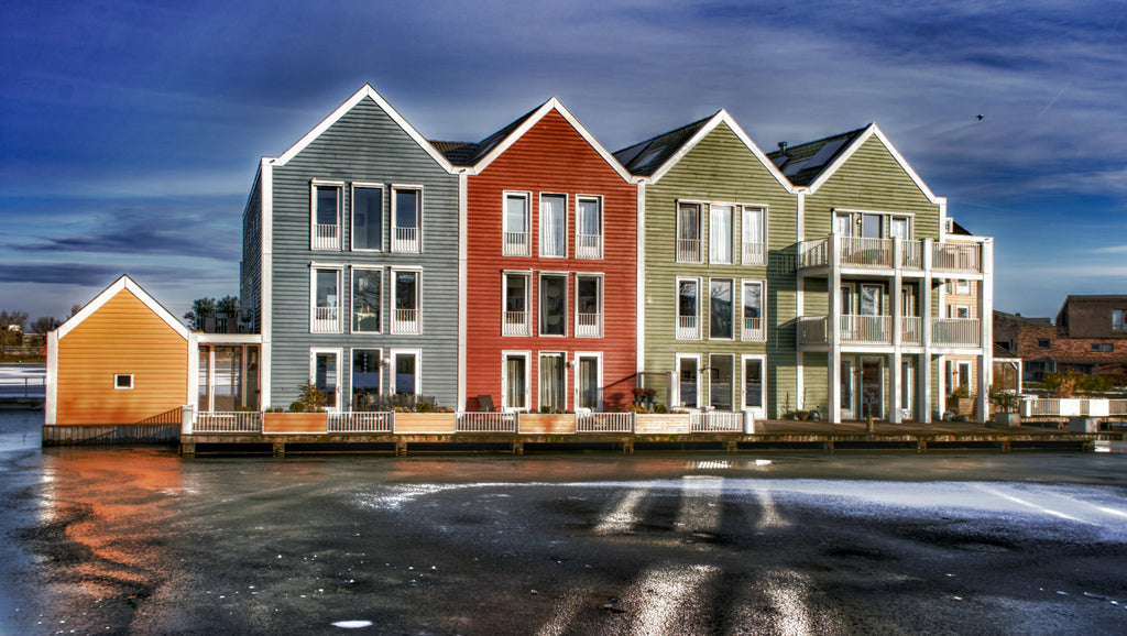 Fine art photograph of colourful blue red and green gabled waterfront houses reflected in a canal in Houten Netherlands, bold architecture wall art print.