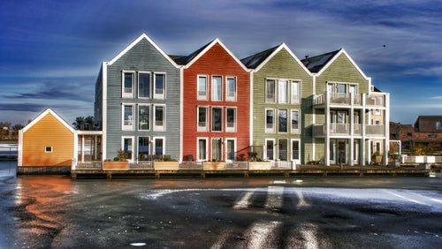 Fine art photograph of colourful blue red and green gabled waterfront houses reflected in a canal in Houten Netherlands, bold architecture wall art print.