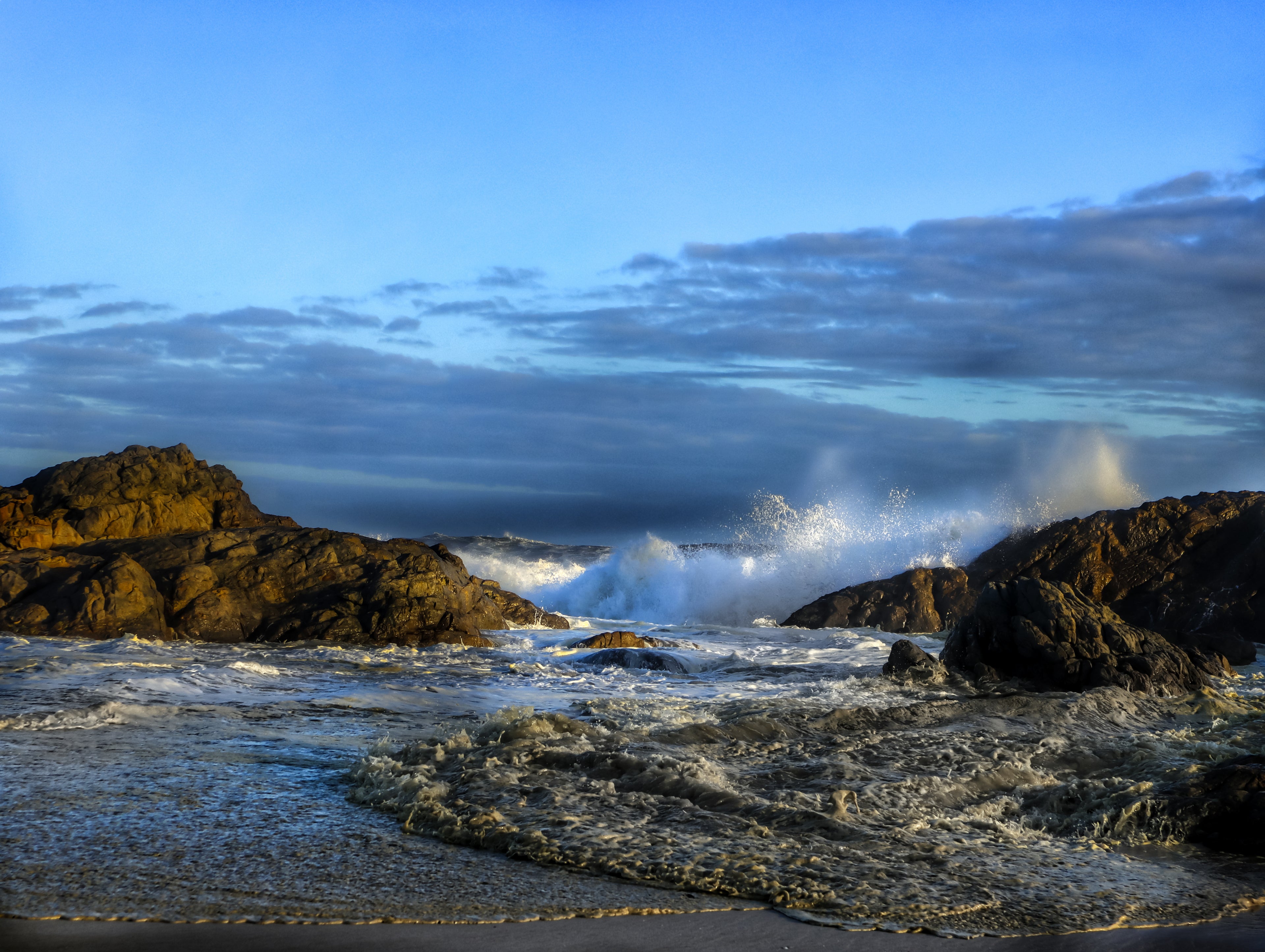 Ocean waves breaking over rocky shoreline at Yzerfontein on South Africa’s west coast under soft coastal light.